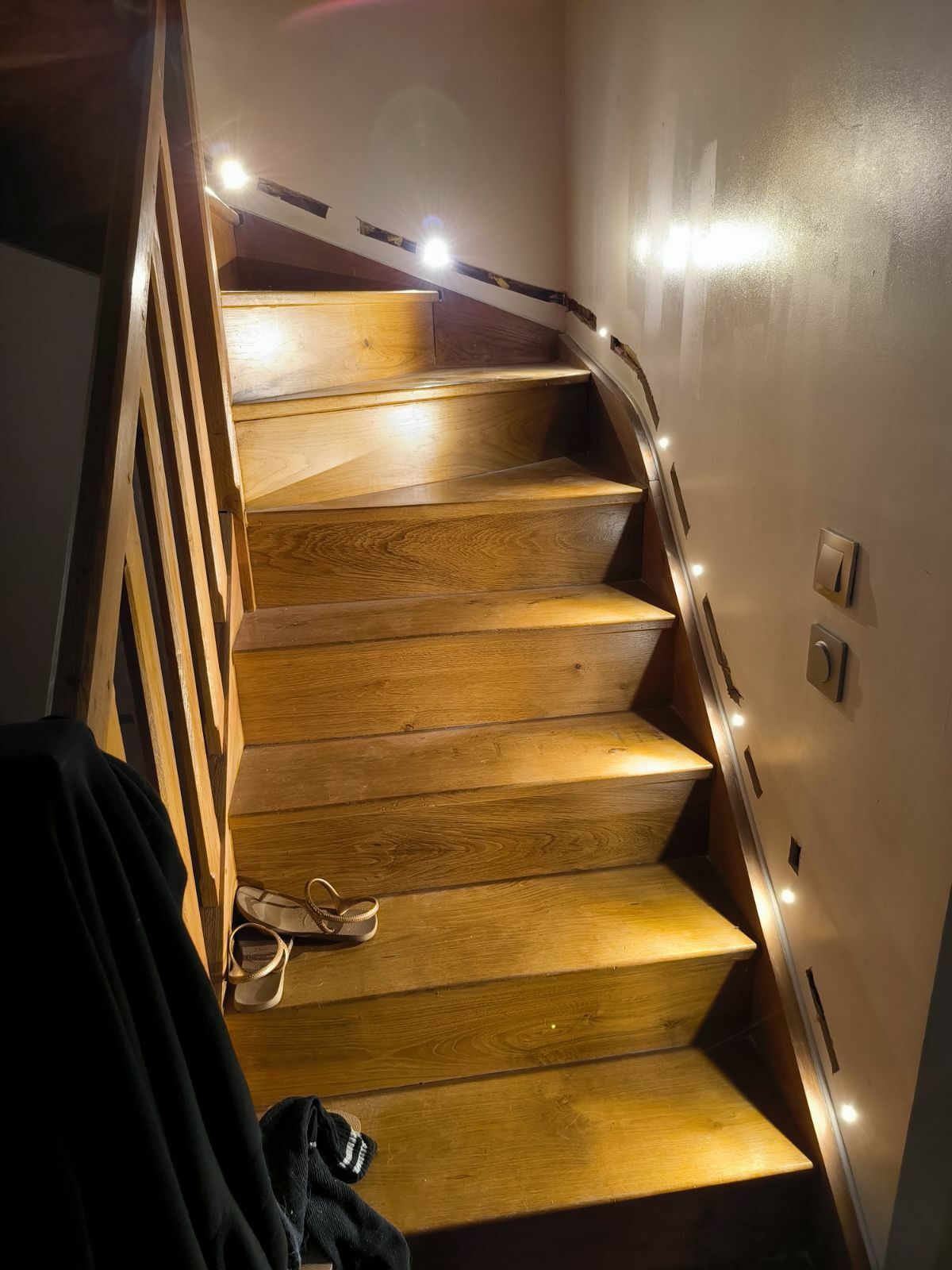 Escalier intérieur en bois avec spots encastrés le long du mur