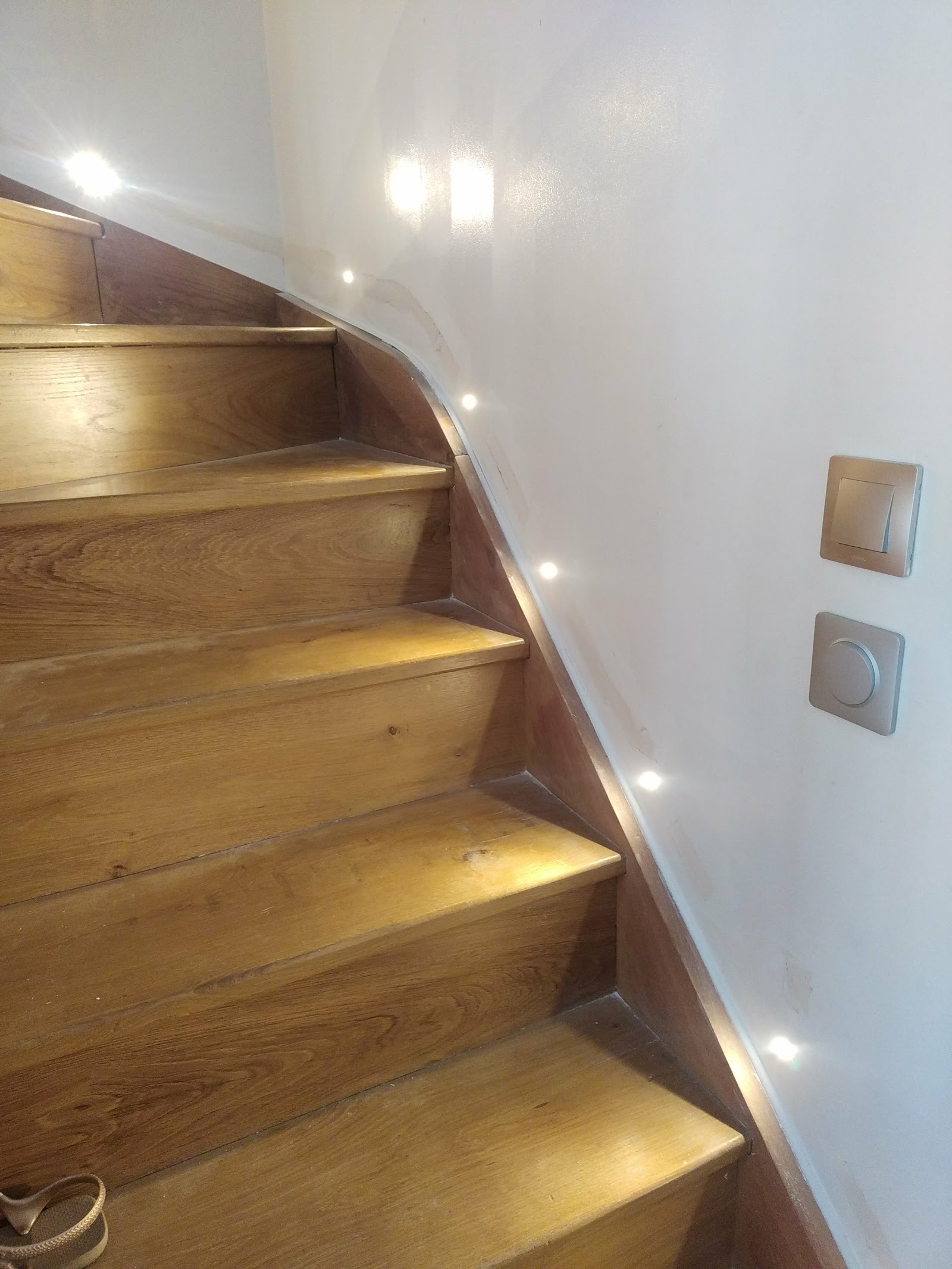 Interrupteur et variateur d'éclairage installés en bas d'un escalier